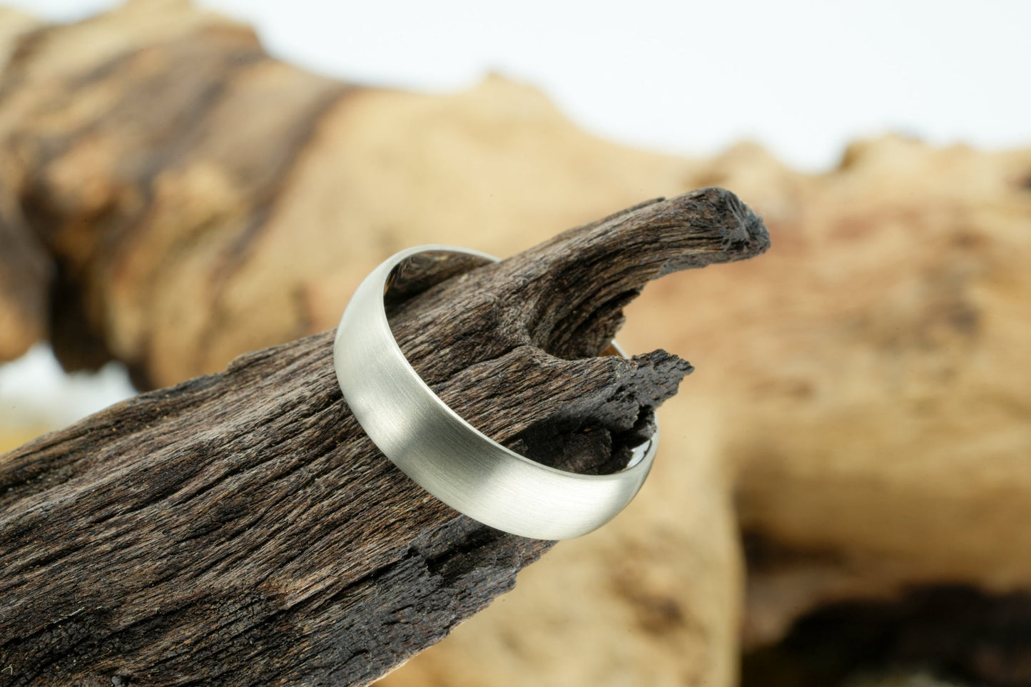 white gold wedding ring on wood